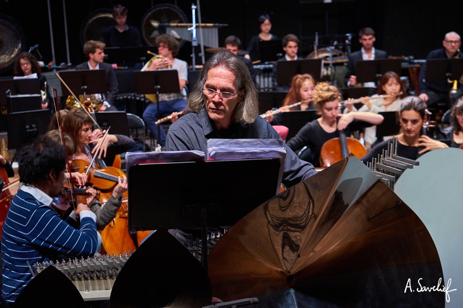 Le cristaliste Michel Deneuve devant l’orchestre en soliste au Cristal Baschet, dans “Leading Astray”, Concerto pour Cristal Baschet & Orchestre de Alexis Savelief