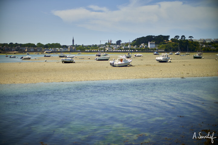 Crique en Bretagne, par une journée ensoleillée ; port d’échouage avec des bateaux échoués sur le sable